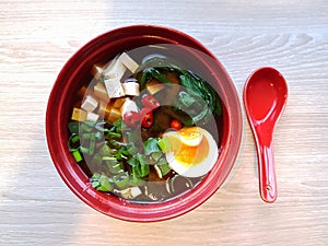 Miso and soba noodle soup with bok choy, tofu, egg, green onion and chili