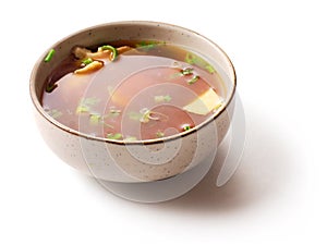 Miso soup with green onion in small dish over white photo