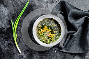 Miso soup with tofu and seaweed. Black background. Top view