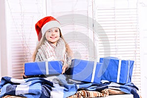 Miss Santa in red hat covered with blanket holds presents