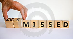 Missed or dismissed symbol. Businessman turns cubes and changes the word `missed` to `dismissed`. Beautiful white background,