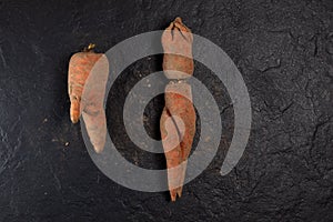 Misshapen carrots on a dark background