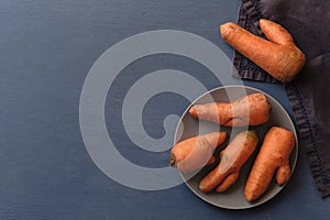 Misshapen ugly fresh carrots on a plate