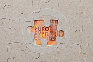 Missing puzzle piece and framed euro. Background with copy space