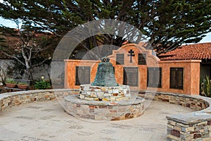 Mission bell in the courtyard, The Carmel Mission Basilica, the mission of San Carlos Borromeo, founded in 1770 by Junipero Serra