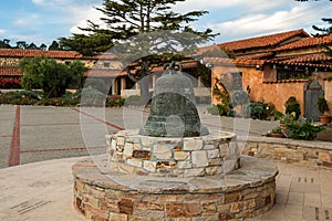 Mission bell in the courtyard, The Carmel Mission Basilica, the mission of San Carlos Borromeo, founded in 1770 by Junipero Serra