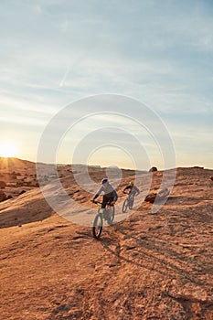 On a mission. Full length shot of two young male athletes mountain biking in the wilderness.