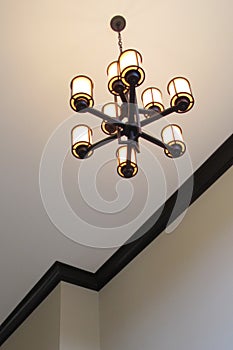 Mission style bronze sconce chandelier hanging from foyer ceiling photo