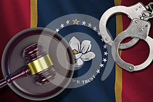 Mississippi new US state flag with judge mallet and handcuffs in dark room. Concept of criminal and punishment
