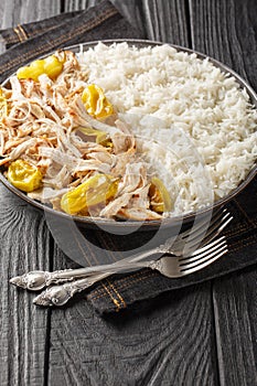 Mississippi shredded chicken made with pepperoncini peppers served with rice closeup on the plate. Vertical
