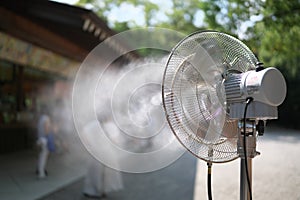 A mist fan operating to cool people visiting a souvenior shop on a hot summer day