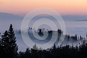 Mist and fog between valley and layers of mountains and hills in Umbria Italy at dusk