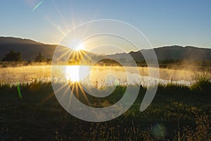 Mist rises over pond as sunrises and warms the air in rural Cromwell photo