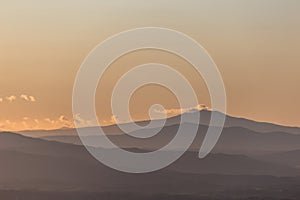 Mist between valley and layers of mountains and hills at sunset, in Umbria Italy