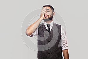 Mistake and sadness. Portrait of sad handsome bearded brunette man in white shirt and waistcoat standing with hopeless face and