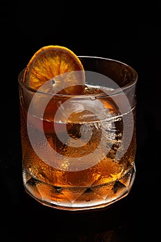 Misted glass of Alcoholic cocktail Old fashioned cocktail with orange slice, bourbon