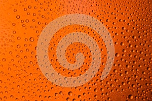 misted glass of beer close up an orange bright background