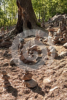 Mistical stone handmade figures near old oak tree in forest shot on day