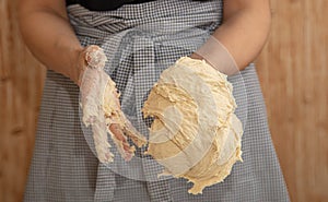 Mistress kneads the dough in the kitchen