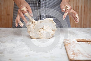 Mistress kneads the dough in the kitchen