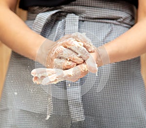 Mistress kneads the dough in the kitchen