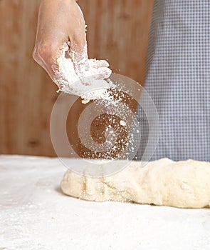 Mistress pours flour in the kitchen