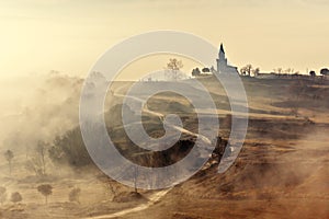 Misty country landscape with church