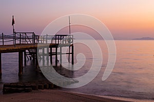 Misty dawn over the sea beach. Stairs to the sea