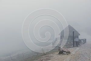 Misty and foggy landscape in the mountain with a hut in the path. autumn or winter season - Image