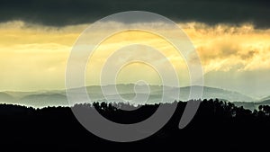 Misty foggy mountain landscape at sunrise,silhouette of trees.