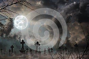 Misty graveyard with old creepy headstones under moon on Halloweeen photo