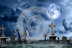 Misty graveyard with old creepy headstones under moon on Halloween