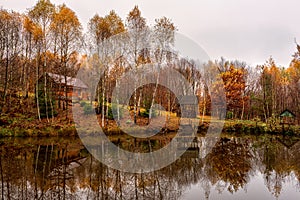 Misty late fall landscape, wild lake in the autumn forest with reflection in the calm water