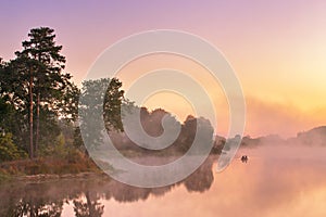 Misty morning on the lake. Fishing boat at a foggy river