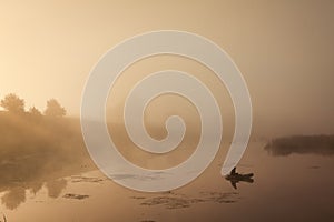 A misty morning by the lake. Small fishing boat at the lake.