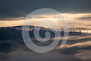 Misty morning landscape over Bucovina village.Sunrise over the foggy hills of the Romanian countryside