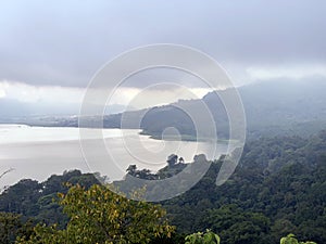 Misty morning in the mountains. Blue lake nature landscape background, Bedugul, Bali, Indonesia