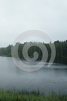 Misty morning on scandinavian lake with rain ripples on water