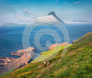 Misty morning view of Koltur Island. Splendid summer scene of outskirts of Velbastadur village, Faroe Islands, Denmark, Europe. B