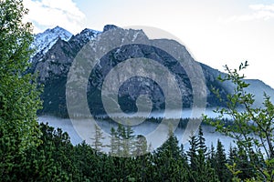 Misty morning view in wet mountain area in slovakian tatra. autumn colored forests