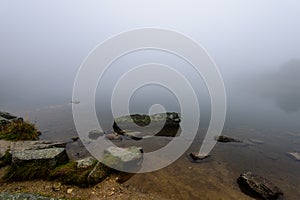 Mlhavé ráno pohled v mokré horské oblasti ve slovenských Tatrách. panorama horského jezera