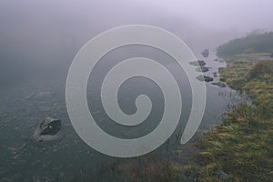 Misty morning view in wet mountain area in slovakian tatra. mountain lake panorama - vintage film look