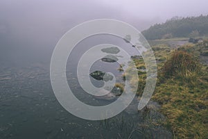 Hmlisté ranné zobrazenie v mokrej horskej oblasti v slovenských Tatrách. panoráma horského jazera - vzhľad vintage filmu