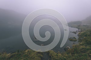 Misty morning view in wet mountain area in slovakian tatra. mountain lake panorama - vintage film look