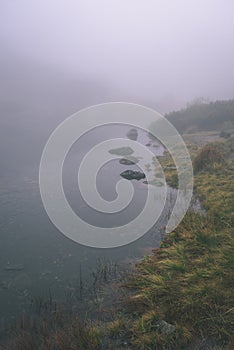 Misty morning view in wet mountain area in slovakian tatra. mountain lake panorama - vintage film look