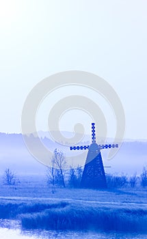 Misty morning view of the windmill on the prairie