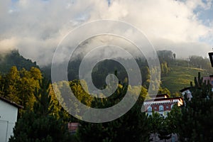 Misty mountain landscape with fir forest. Beautiful landscape with mountain view, cable car. Postcard view