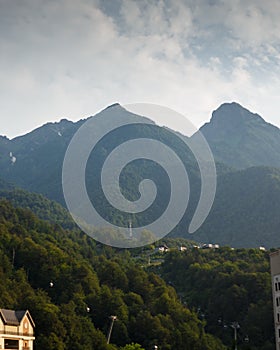 Misty mountain landscape with fir forest. Beautiful landscape with mountain view, cable car. Postcard view. Travel concept