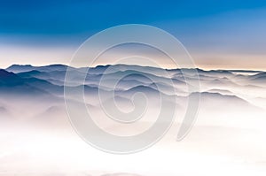 Misty mountains landscape view with blue sky photo