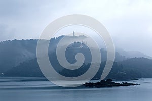 Misty mountains by Sun Moon Lake on a foggy morning, with a pagoda on the distant mountaintop